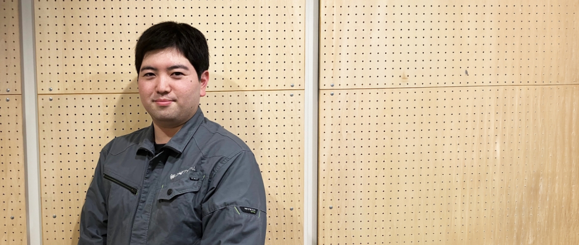 黒の作業着を着て写るO.K.さん